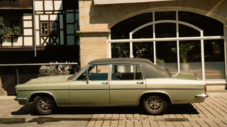 Ein Auto, ein Oldtimer vor einem Haus. Wertgutachten soll erstellt werden